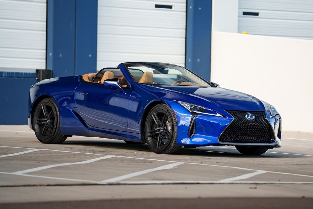 A vibrant blue Lexus convertible with tan interior and black wheels is parked outside in a sunny lot, showcasing a glossy, well-protected finish that resists high-altitude UV damage, paint fade, and oxidation.