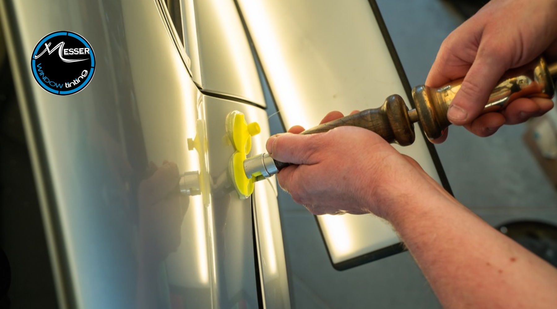 A close-up view of paintless dent repair being performed on a silver vehicle door in Parker, Colorado, illustrating the hands-on process behind the question “What is Paintless Dent Repair”.