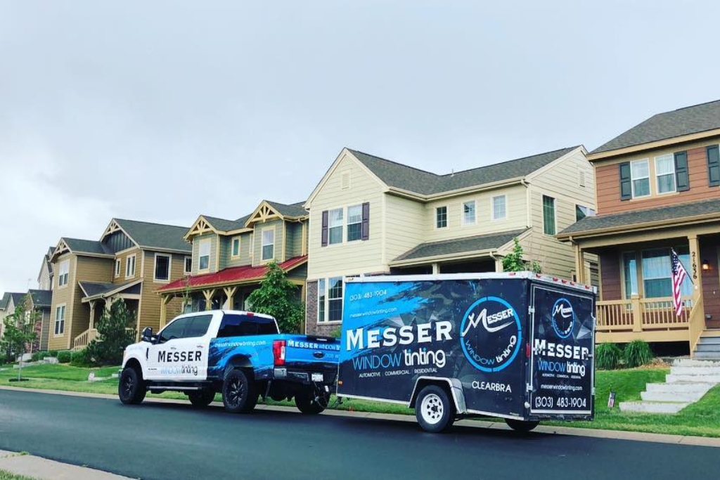 Messer Window Tinting’s branded truck and trailer parked in a suburban Parker, Colorado neighborhood, promoting their mobile paintless dent repair and window tinting services.