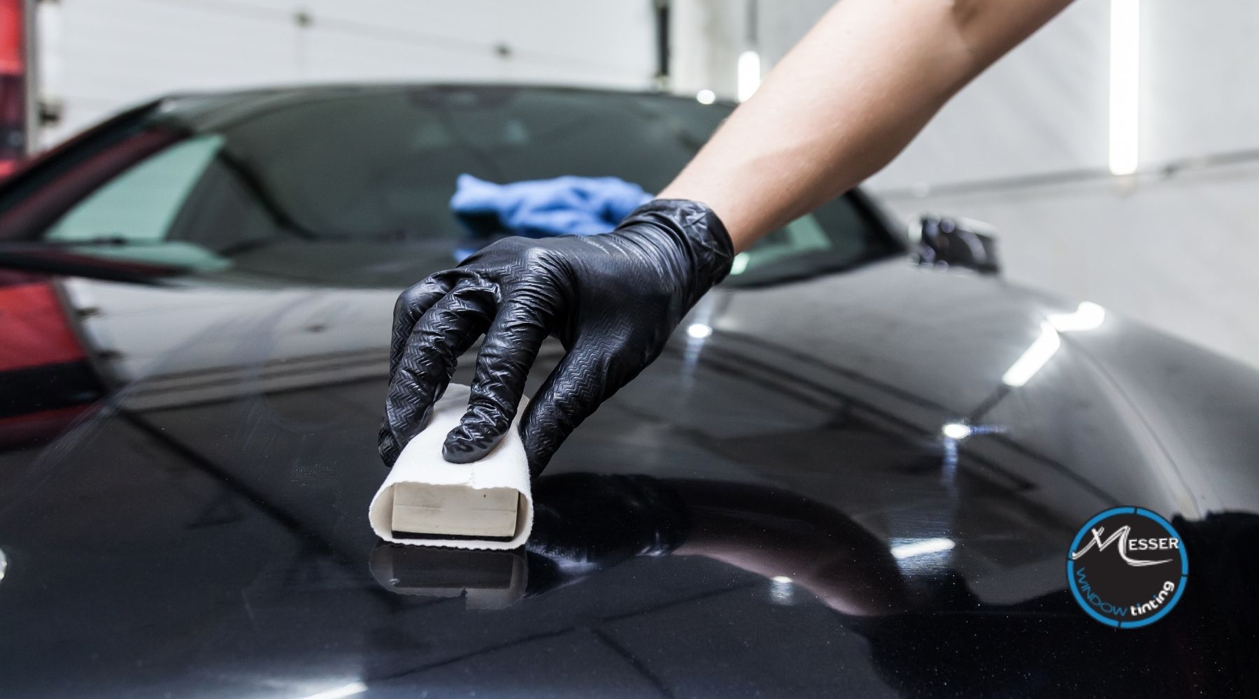 Technician applying ceramic coating to a black car surface for paint protection in Parker, CO