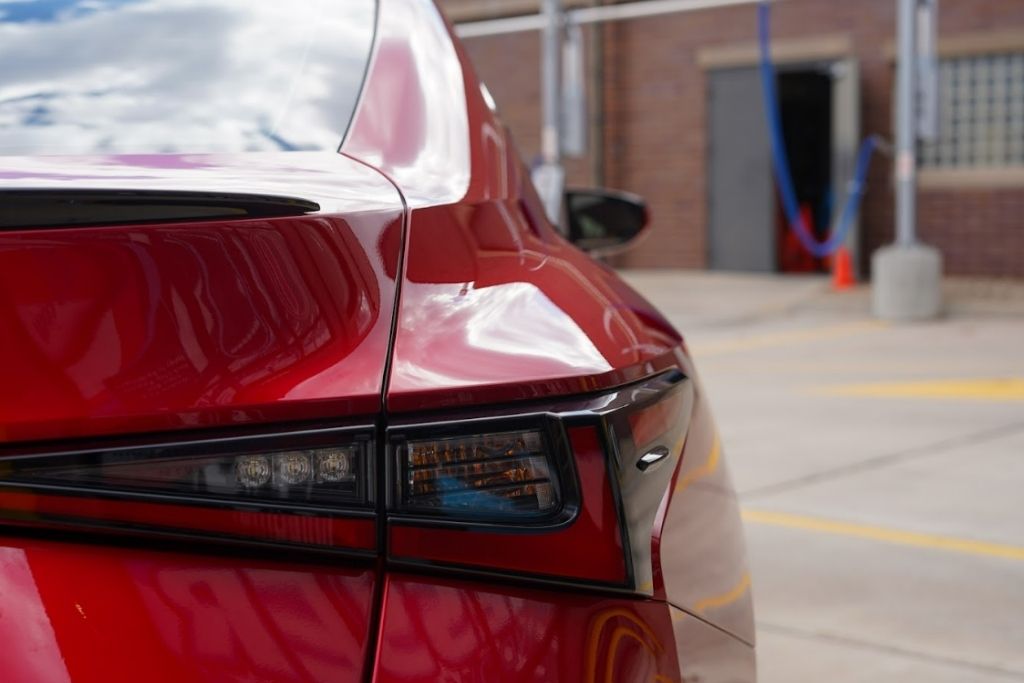 Red car exterior with glossy ceramic coating finish reflecting light after professional paint protection treatment