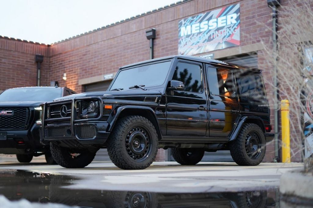 Black Mercedes-Benz G-Class with tinted windows parked outside Messer Window Tinting shop in Parker, Colorado.